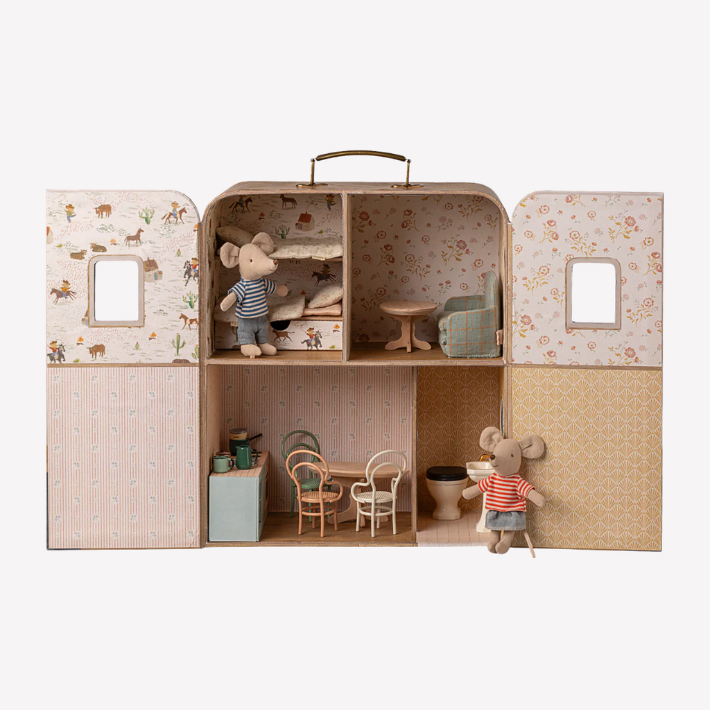 Children's toy house with furniture and small figures on a white background